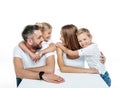 Close-up portrait of smiling family in white t-shirts hugging and looking at each other Royalty Free Stock Photo