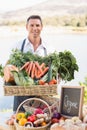 Smiling farmer holding a basket of vegetables Royalty Free Stock Photo