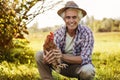 Smiling farmer holding a chicken