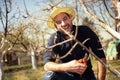 Smiling farmer pruning branches of fruit tree