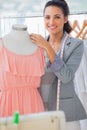 Smiling fashion designer adjusting dress Royalty Free Stock Photo