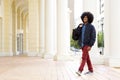 Smiling fashion guy walking outside with travel bag Royalty Free Stock Photo