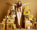 Smiling fashion-monger among 2 piles of golden gifts rejoicing