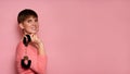 Smiling, fashionable Caucasian girl, holding handcuffs in her hands. Isolated on a pink background. The concept of bdsm Royalty Free Stock Photo