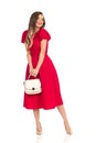 Smiling Fashionable Woman In Red Dress, Gold High Heels And Beige Purse Royalty Free Stock Photo