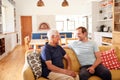 Smiling Father With Adult Son Relaxing On Sofa At Home Royalty Free Stock Photo