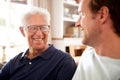 Smiling Father With Adult Son Relaxing On Sofa At Home Royalty Free Stock Photo