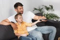 Smiling father and bored son clicking Royalty Free Stock Photo
