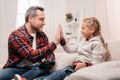 smiling father and daughter giving high five while playing with joysticks Royalty Free Stock Photo