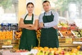 Smiling father and daughter, owners of green grocery store, standing among stalls of fruits and vegetables Royalty Free Stock Photo