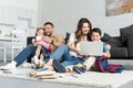 smiling father and daughter taking selfie on smartphone while mother and son using laptop together Royalty Free Stock Photo