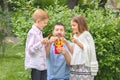 Smiling father and kids eating fresh vegetables in nature Ã¢â¬â happy dad holding colorful peppers sliced in form of french fries Royalty Free Stock Photo