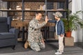 smiling father in military uniform giving high five to little son Royalty Free Stock Photo