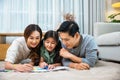 Smiling Father, Mother and daughter drawing together on paper at home Royalty Free Stock Photo