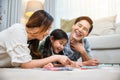 Smiling Father, Mother and daughter drawing together on paper at home Royalty Free Stock Photo