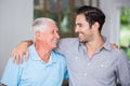 Smiling father and son with arm around