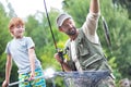 Smiling father and son catching fish on pier Royalty Free Stock Photo