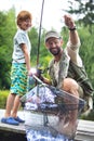 Smiling father and son catching fish on pier Royalty Free Stock Photo