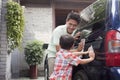 Smiling Father and Son Clean their Minivan Together