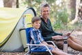 Smiling father and son with laptop in forest Royalty Free Stock Photo