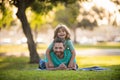 Smiling father and son laying on grass in summer park outdoor. People having fun outdoors. Concept of happy vacation and Royalty Free Stock Photo