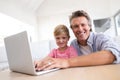 Smiling father and son using laptop in living room Royalty Free Stock Photo