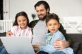 smiling father with two adorable kids using laptop together Royalty Free Stock Photo