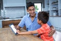 Smiling father using tablet with his son