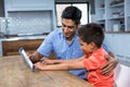 Smiling father using tablet with his son Royalty Free Stock Photo