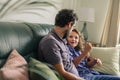 Smiling father and young son talking together on their sofa Royalty Free Stock Photo