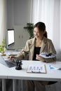 Smiling female accountant using laptop computer and checking financial reports at her office desk. Royalty Free Stock Photo