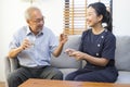 Female asian nurse takes care of sick senior man, help to remind to take a pill. Royalty Free Stock Photo