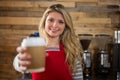 Smiling female barista holding disposable coffee cup in cafe Royalty Free Stock Photo