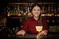 Smiling female bartender serving a delicious yellow cocktail Royalty Free Stock Photo