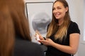 Smiling Female Beautician Showing Beauty Product To Customer