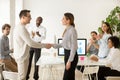 Female boss promoting rewarding handshaking male employee while Royalty Free Stock Photo