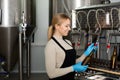 Smiling female brewery worker with bottling machinery Royalty Free Stock Photo