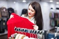 Smiling female buyer choosing sweater