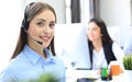 Smiling female call centre operator doing her job with a headset while looking at camera. Royalty Free Stock Photo