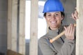 smiling female carpenter hammering wood Royalty Free Stock Photo