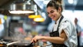 Smiling female chef actively cooking in restaurant kitchen Royalty Free Stock Photo