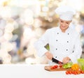 Smiling female chef chopping vegetables