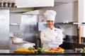 Smiling female chef with cut vegetables in kitchen Royalty Free Stock Photo