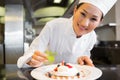 Smiling female chef garnishing food in kitchen Royalty Free Stock Photo