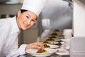 Smiling female chef garnishing food in kitchen Royalty Free Stock Photo