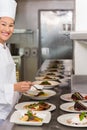 Smiling female chef garnishing food in kitchen Royalty Free Stock Photo