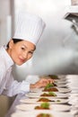 Smiling female chef garnishing food in kitchen Royalty Free Stock Photo
