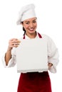 Smiling female chef opening pizza box Royalty Free Stock Photo