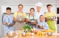 Smiling female chef posing with group of tweens at cooking masterclass Royalty Free Stock Photo