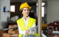 Smiling female civil engineer standing with papers at construction site Royalty Free Stock Photo